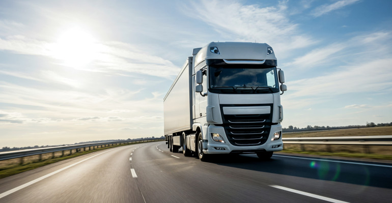 semi-truck-driving-sunny-highway.jpg