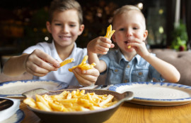 medium-shot-smiley-boys-eating-fries.jpg
