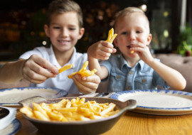 medium-shot-smiley-boys-eating-fries.jpg