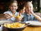 medium-shot-smiley-boys-eating-fries.jpg
