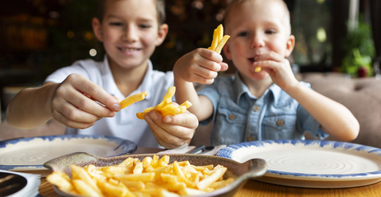 medium-shot-smiley-boys-eating-fries.jpg